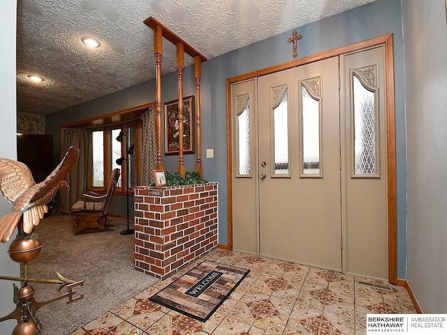 foyer with a textured ceiling and baseboards