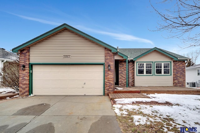 single story home featuring an attached garage, driveway, a shingled roof, and brick siding