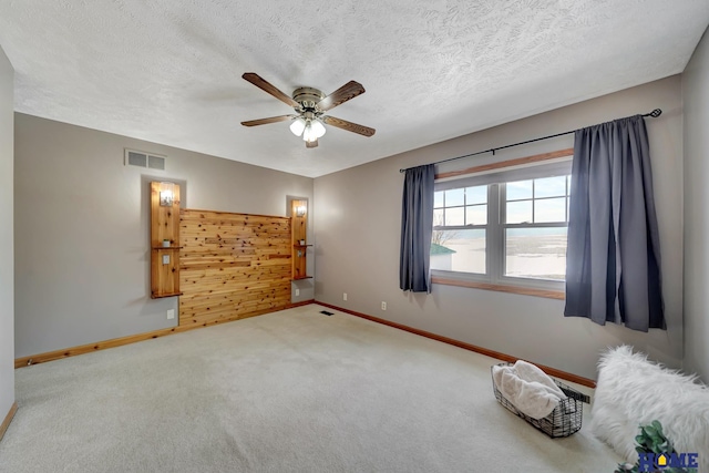 unfurnished bedroom with visible vents, carpet flooring, ceiling fan, a textured ceiling, and baseboards