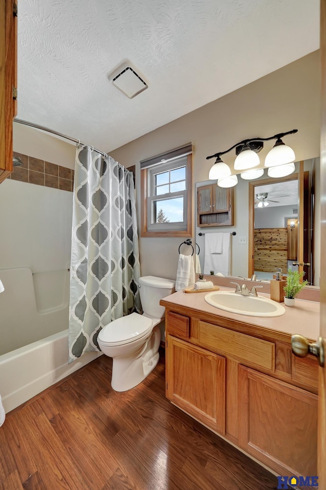 bathroom featuring a textured ceiling, toilet, wood finished floors, vanity, and visible vents