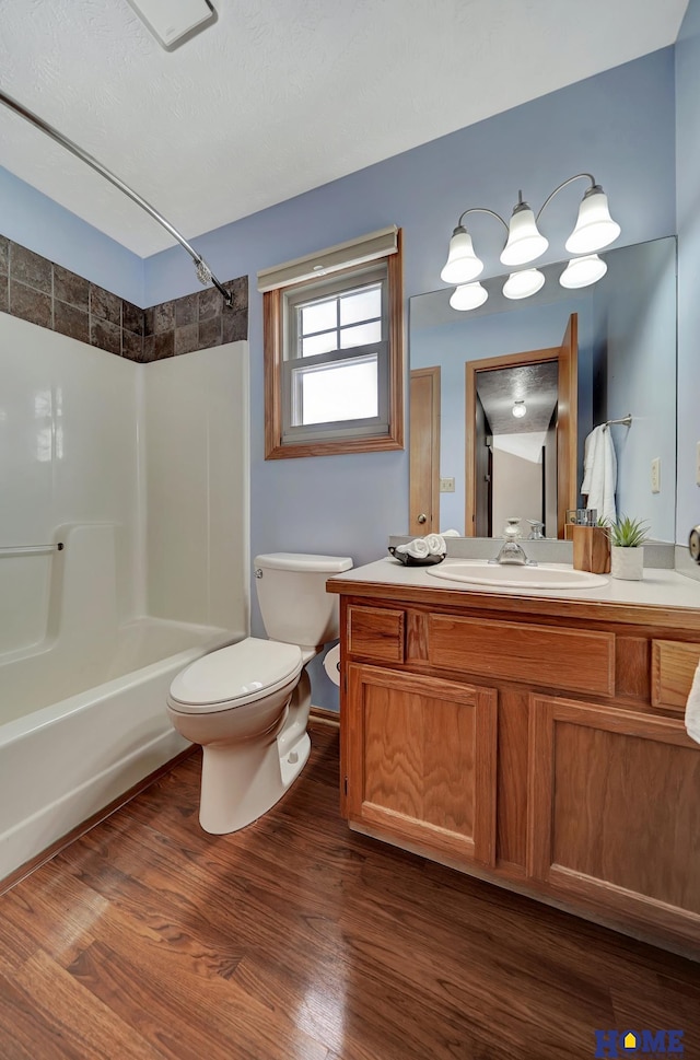 bathroom with bathing tub / shower combination, vanity, toilet, and wood finished floors