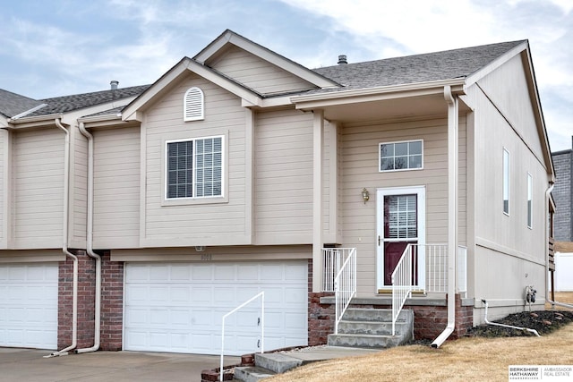 view of front of house featuring concrete driveway, a shingled roof, an attached garage, and brick siding