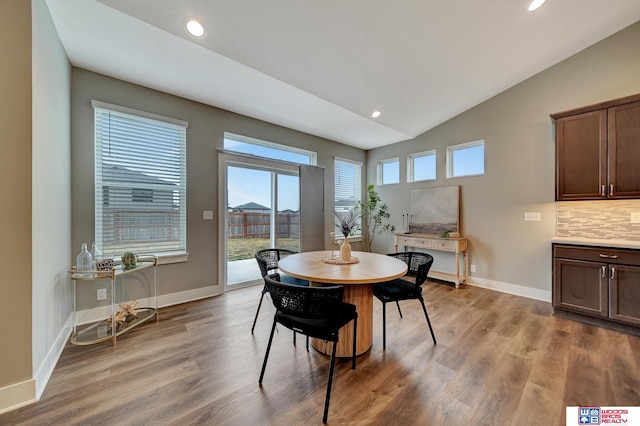 dining area with lofted ceiling, baseboards, wood finished floors, and recessed lighting