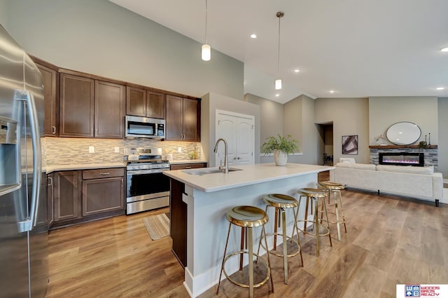 kitchen featuring appliances with stainless steel finishes, light countertops, light wood-style floors, and backsplash