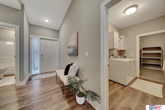 entryway with washer and clothes dryer, light wood-type flooring, and baseboards