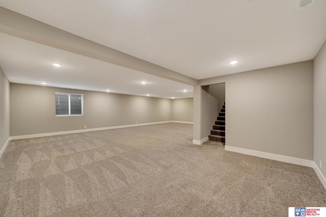 finished below grade area with baseboards, stairway, carpet flooring, and recessed lighting