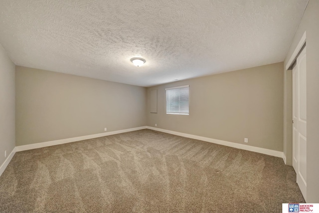 carpeted empty room featuring baseboards and a textured ceiling