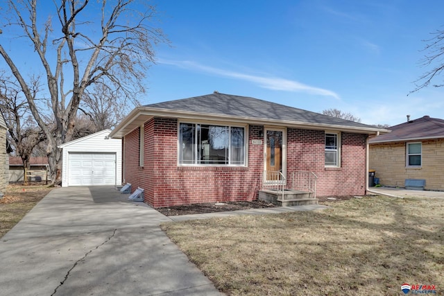 view of front of property with an outbuilding, a detached garage, roof with shingles, concrete driveway, and brick siding