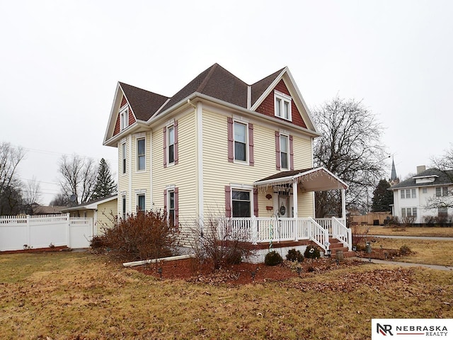 view of front of property with fence, a porch, and a front yard