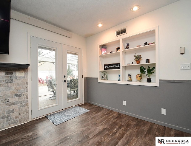 doorway with dark wood-style floors, french doors, visible vents, and built in shelves