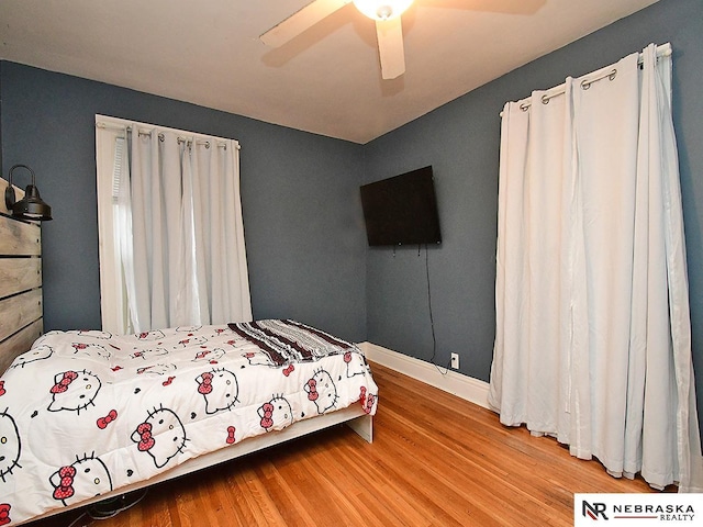 bedroom with ceiling fan, wood finished floors, and baseboards