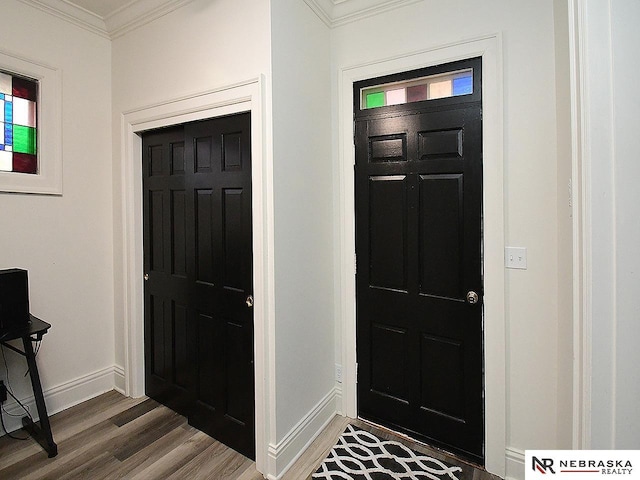 entryway with baseboards, wood finished floors, and crown molding