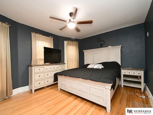 bedroom featuring a ceiling fan, light wood-style flooring, and baseboards