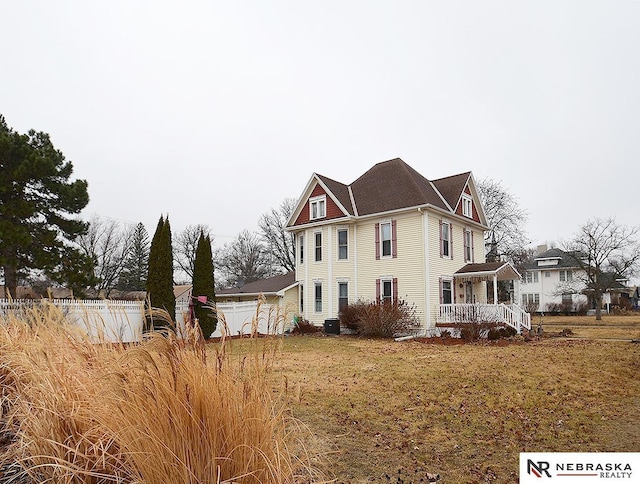 view of property exterior featuring a yard, fence, and central air condition unit