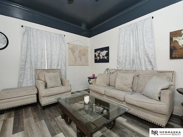 living area with baseboards, ornamental molding, and wood finished floors