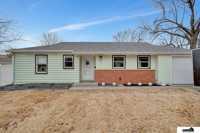 ranch-style house featuring concrete driveway, brick siding, an attached garage, and a shingled roof