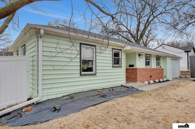 view of front of house with brick siding, fence, and an attached garage