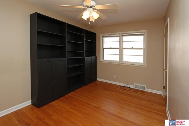 unfurnished bedroom featuring a ceiling fan, baseboards, visible vents, and light wood finished floors