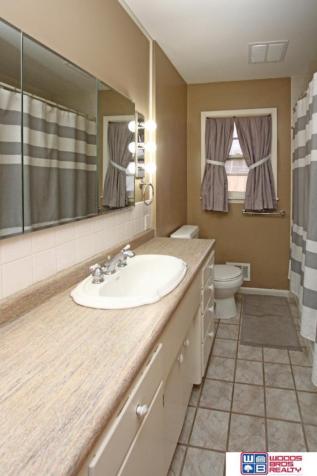 bathroom with toilet, visible vents, backsplash, and vanity