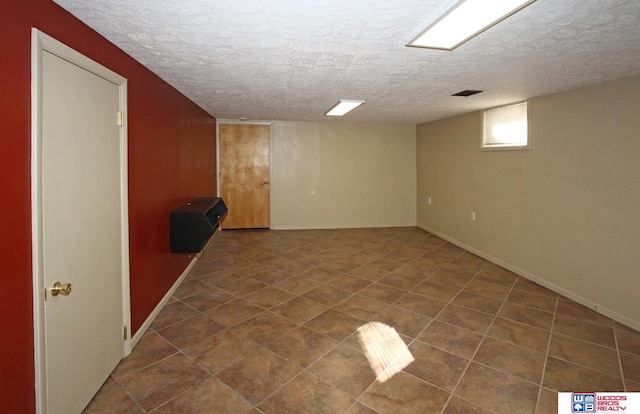 basement featuring visible vents and a textured ceiling