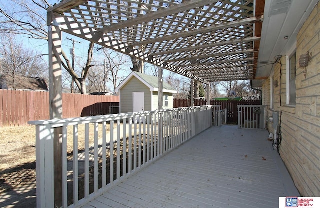 deck featuring an outbuilding, a fenced backyard, a storage unit, and a pergola