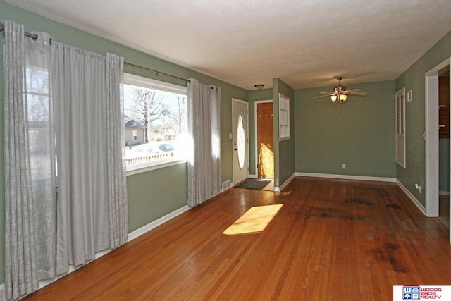 spare room with ceiling fan, baseboards, and wood finished floors