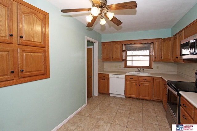 kitchen with stainless steel appliances, brown cabinets, a sink, and decorative backsplash