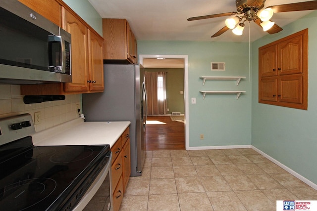 kitchen featuring visible vents, brown cabinetry, appliances with stainless steel finishes, light countertops, and backsplash