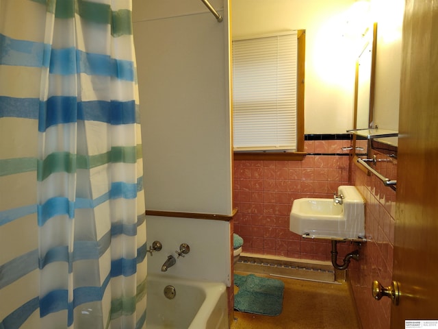 full bathroom with shower / bath combination with curtain, a sink, and tile walls