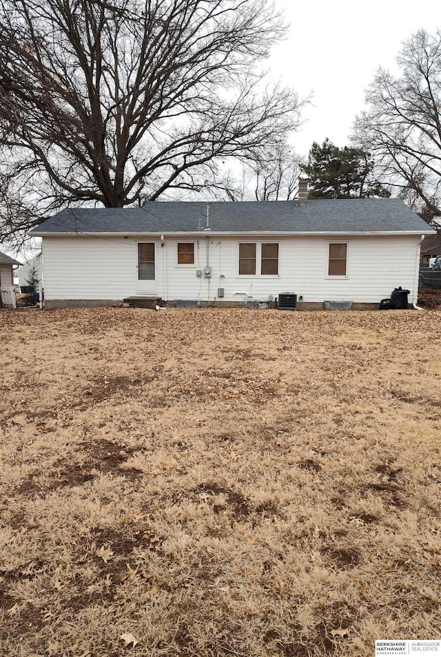 back of property featuring a chimney and central AC unit