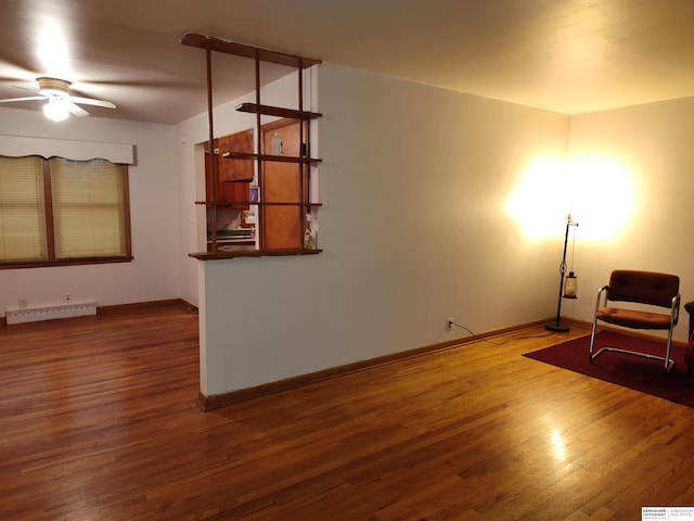 living area with a ceiling fan, a baseboard radiator, baseboards, and wood finished floors