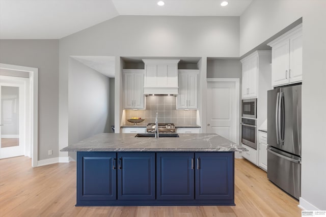 kitchen featuring stainless steel appliances, light wood-style flooring, a sink, and white cabinetry