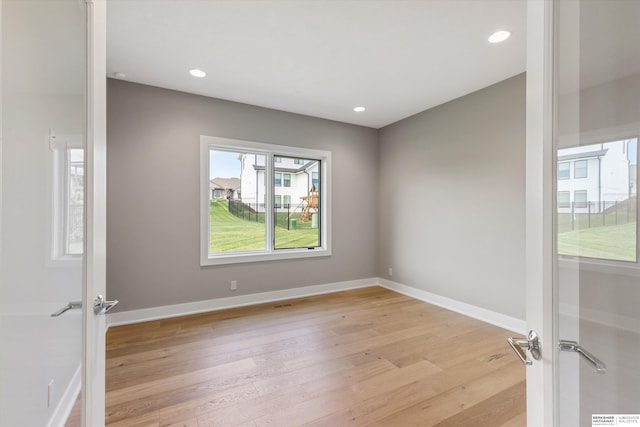 spare room with recessed lighting, light wood-style flooring, and baseboards