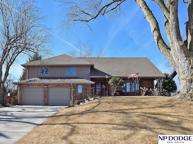 view of front of property with brick siding, an attached garage, board and batten siding, a front yard, and driveway