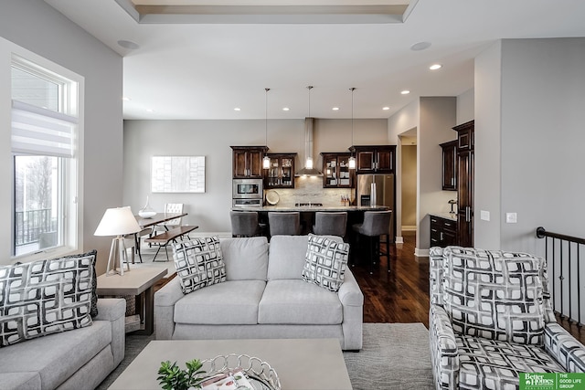 living area with baseboards, dark wood-type flooring, and recessed lighting