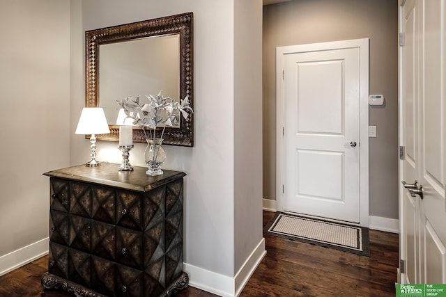 doorway with wood finished floors and baseboards