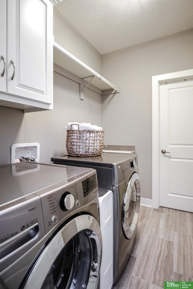 laundry room with washer and dryer, cabinet space, a textured ceiling, and baseboards