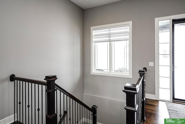 staircase featuring baseboards and wood finished floors