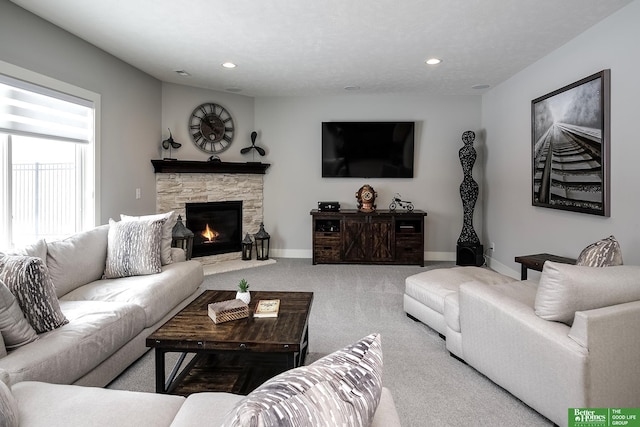 carpeted living room featuring a stone fireplace, recessed lighting, visible vents, and baseboards