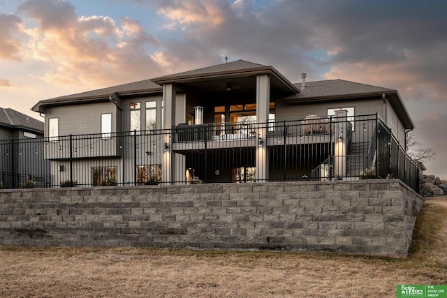 back of property at dusk featuring stairs