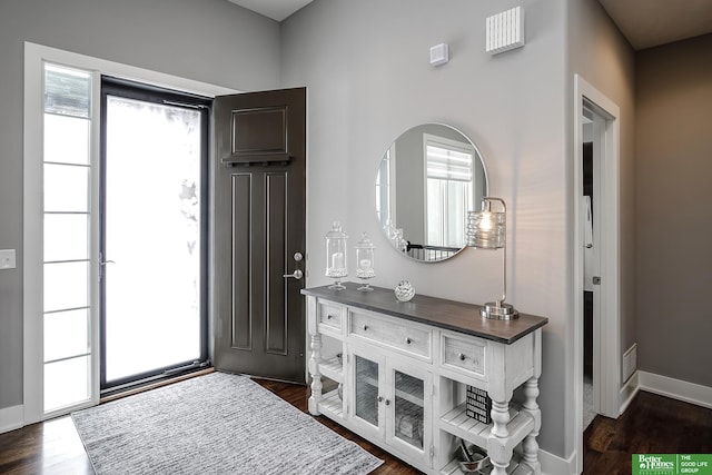 foyer entrance with dark wood-style flooring and baseboards