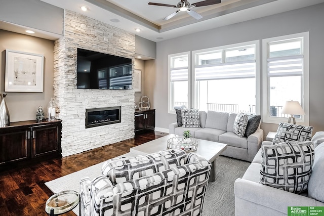 living area featuring baseboards, ceiling fan, dark wood-type flooring, a fireplace, and recessed lighting