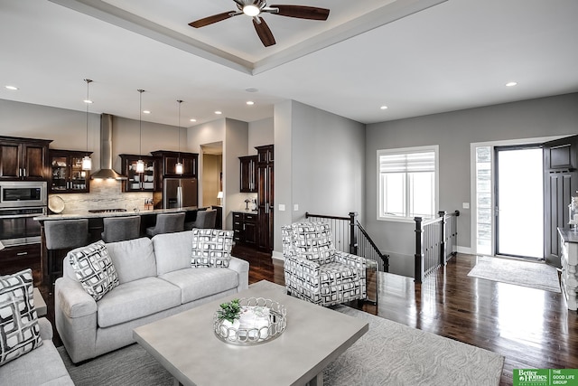 living room with baseboards, dark wood finished floors, a ceiling fan, and recessed lighting