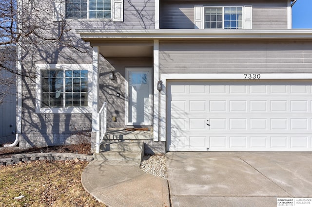 entrance to property with driveway and a garage