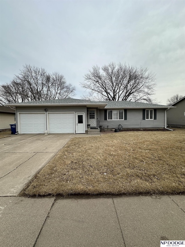 single story home featuring a garage, concrete driveway, and a front yard