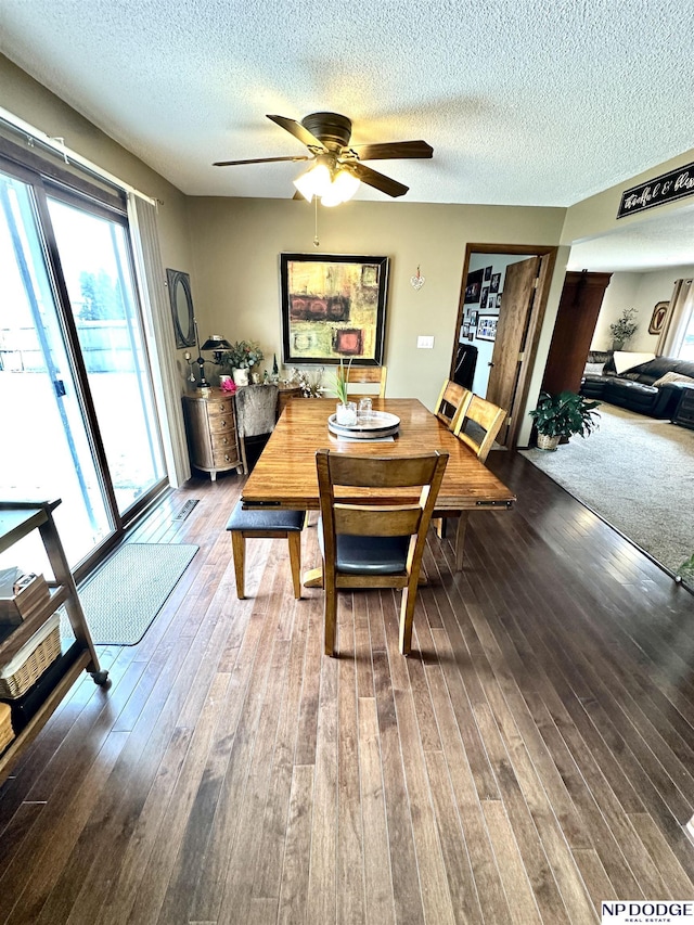 dining room with ceiling fan, a textured ceiling, and wood finished floors