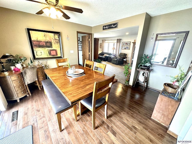 dining area featuring a textured ceiling, ceiling fan, wood finished floors, and visible vents