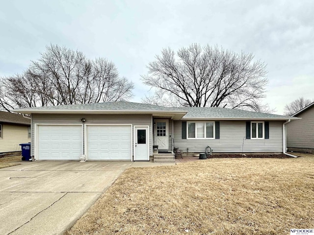 single story home featuring a garage, a front lawn, and concrete driveway