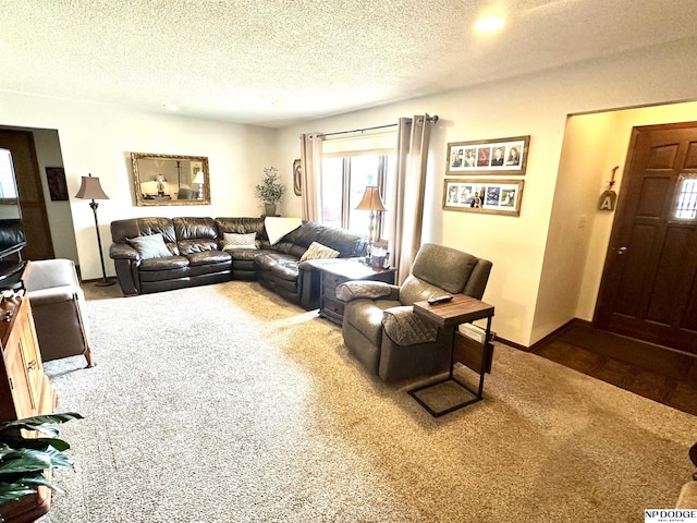 carpeted living area with a textured ceiling and baseboards