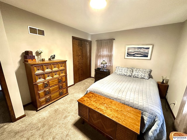 bedroom with a closet, light colored carpet, visible vents, and baseboards